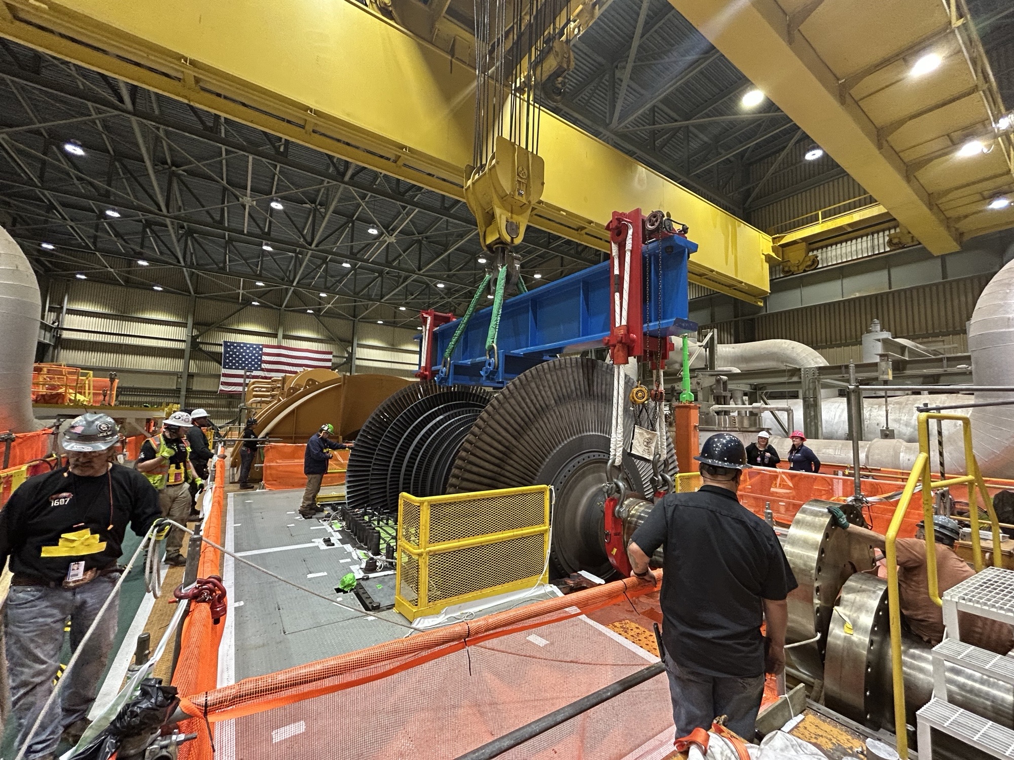 Twin-Path and Helix Slings used together Nuclear Power | Slingmax® Rigging Solutions | Official Site | Twin-Path® Slings Industrial facility with a large yellow overhead crane, heavy machinery, and workers in hard hats and vests examining equipment.